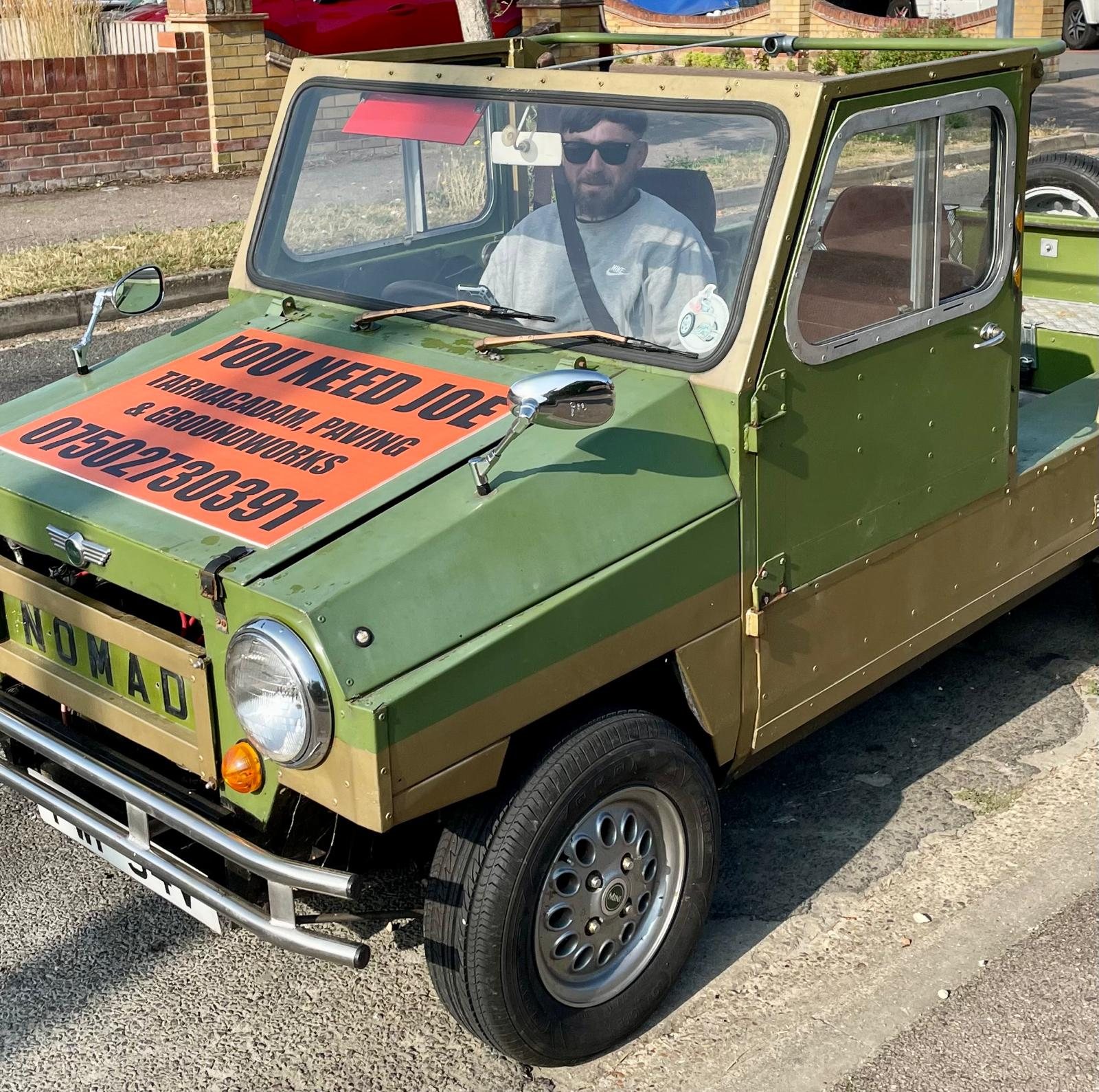 Joe driving the green You Need Joe wagon, signwritten for tarmacadam, paving and groundworks