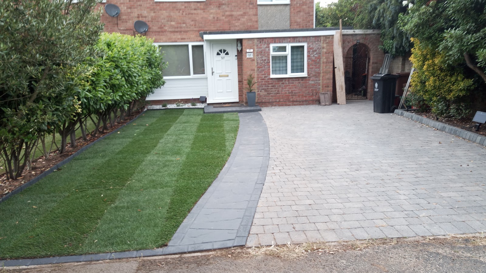 Completed front garden with new turf, charcoal edging and a block-paved driveway
