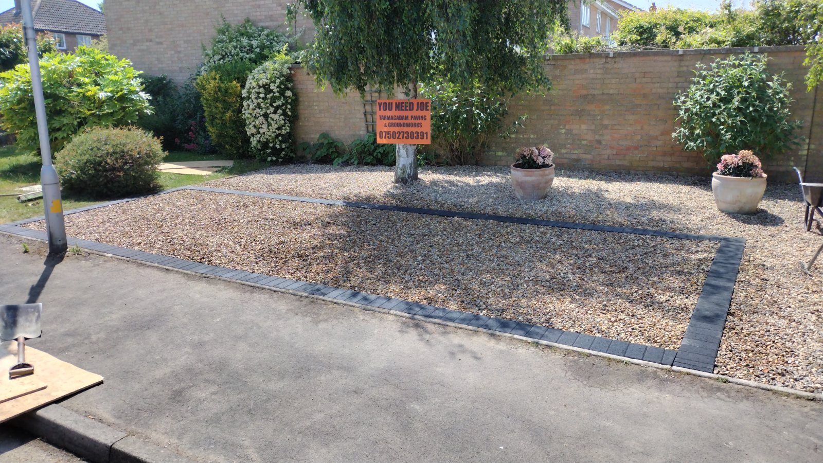 Block-paved driveway beside striped new turf and charcoal edging