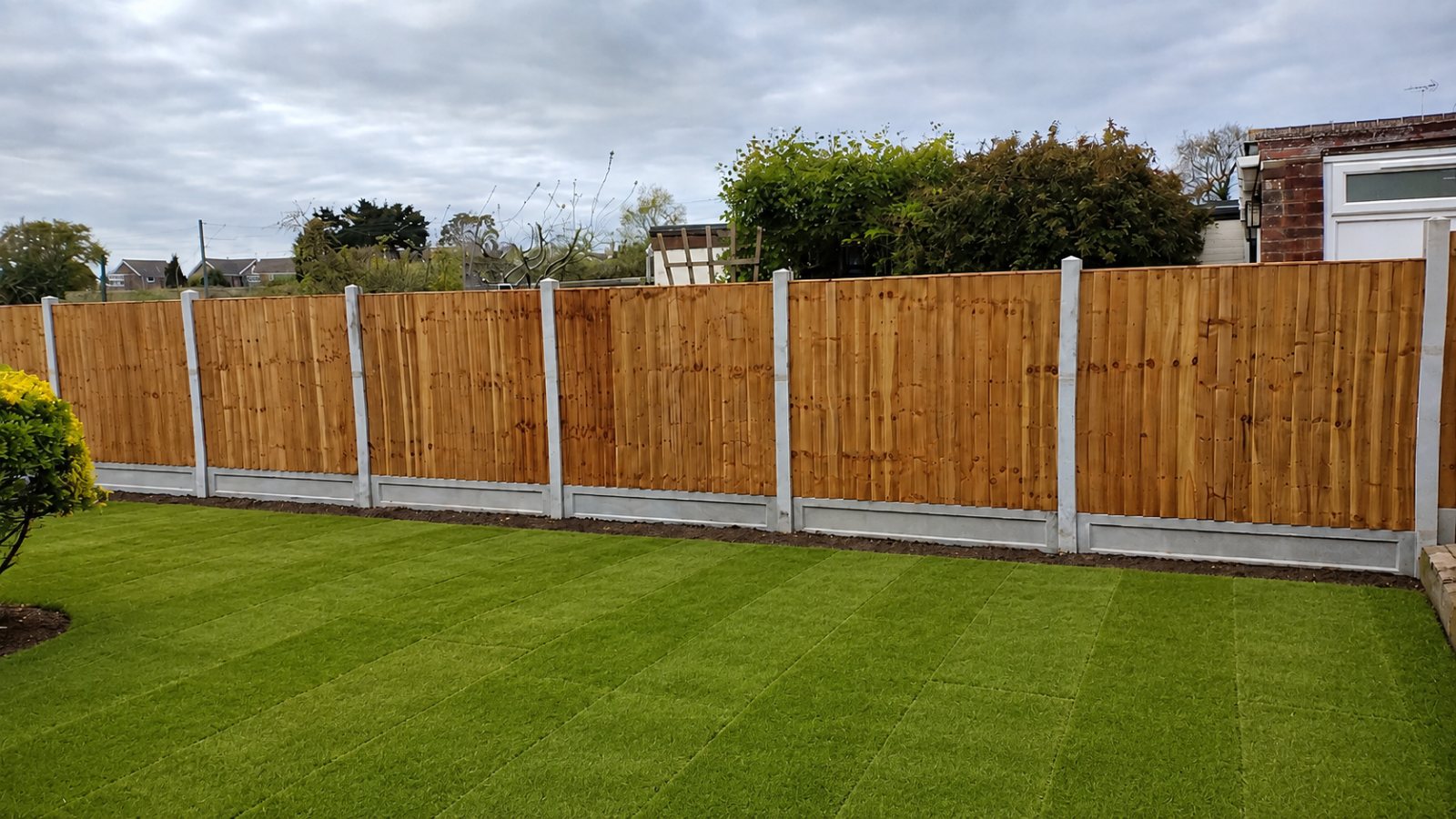 Black featheredge fencing behind a new porcelain patio