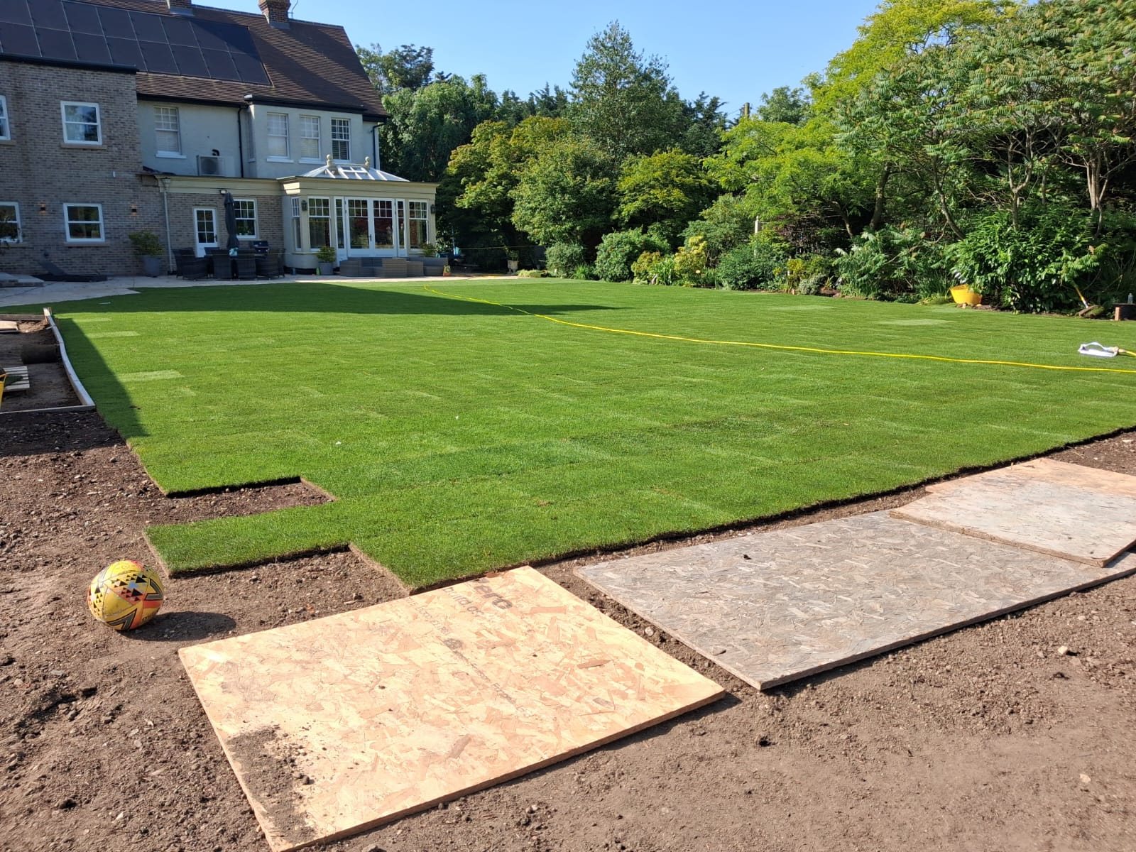 Curved path cut through a lawn beside flower beds