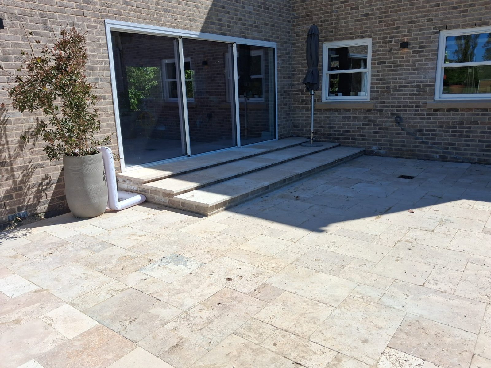 Curved brick steps and circular paving outside french doors